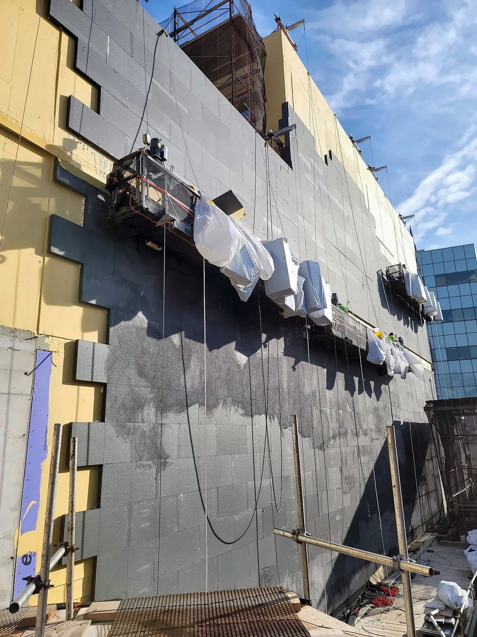 EIFS base coat and mesh - Swing-stage base coat on a commercial facade, Long Island City